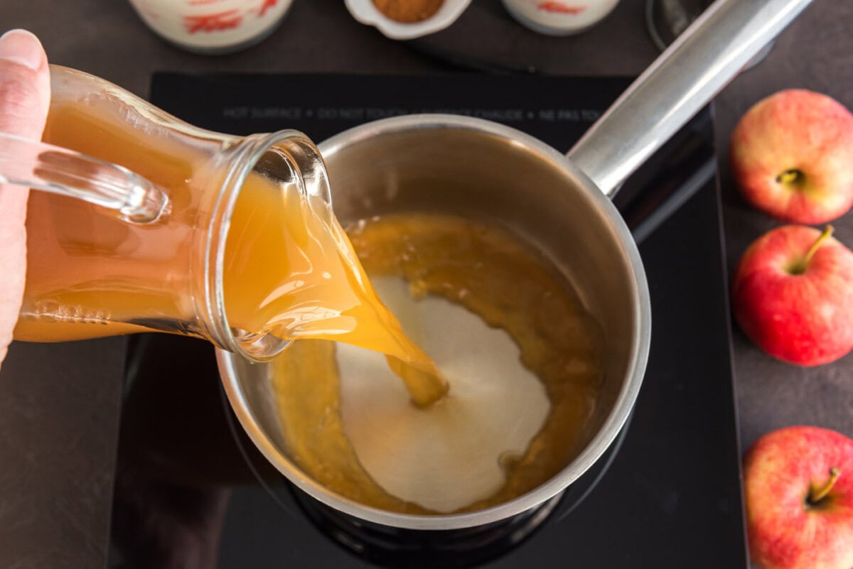 pouring apple cider into saucepan