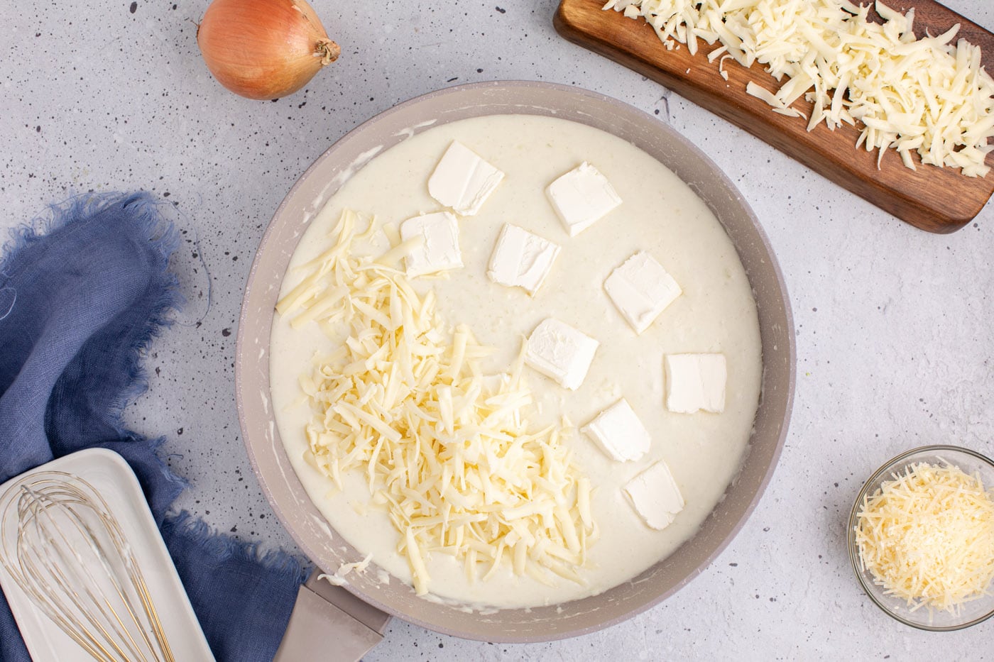 adding butter and mozzarella cheese to roux in skillet
