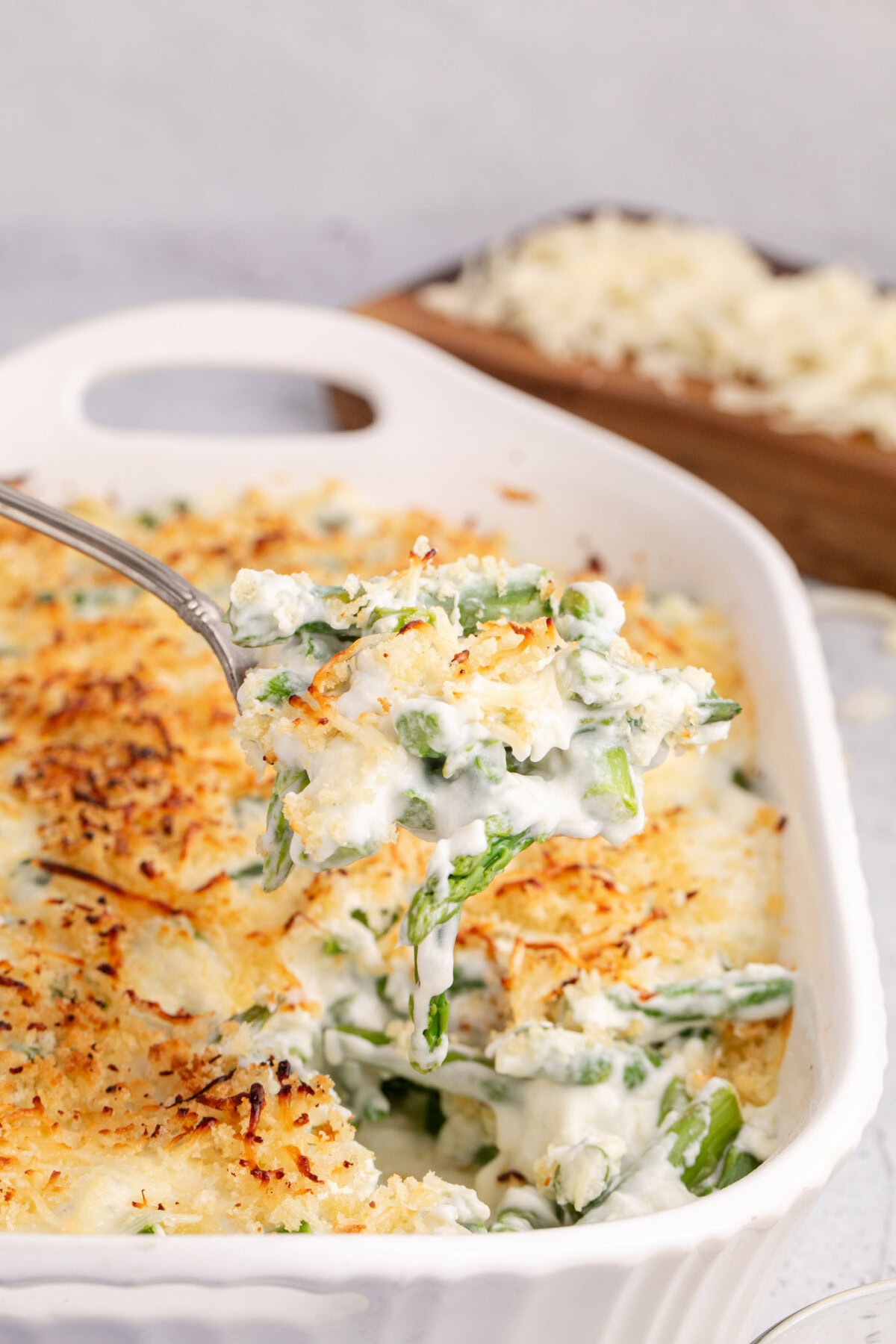 Spoonful of Asparagus Casserole being lifted out of the casserole dish