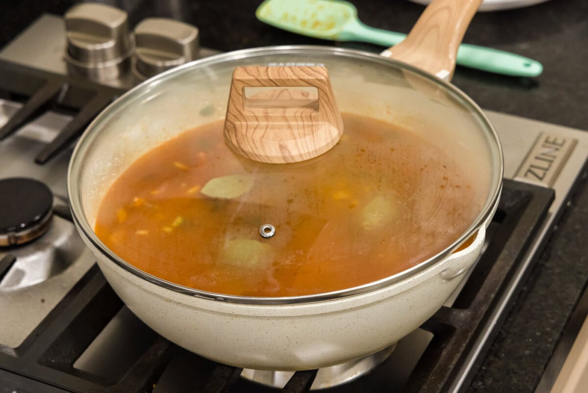 simmering red bean mixture in skillet with a lid