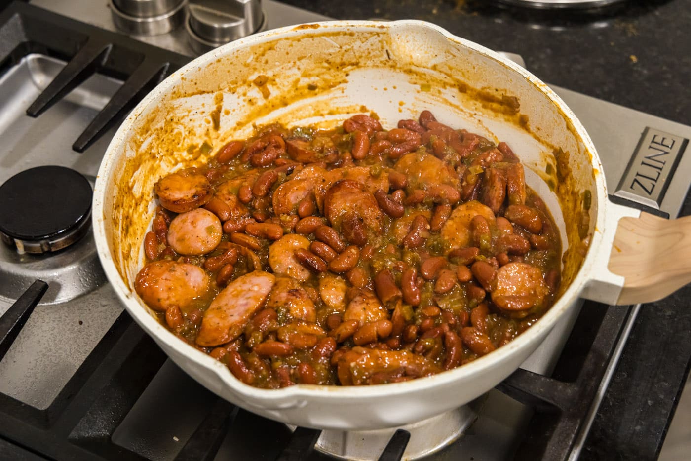 sliced andouille sausage with cajun red beans in a skillet