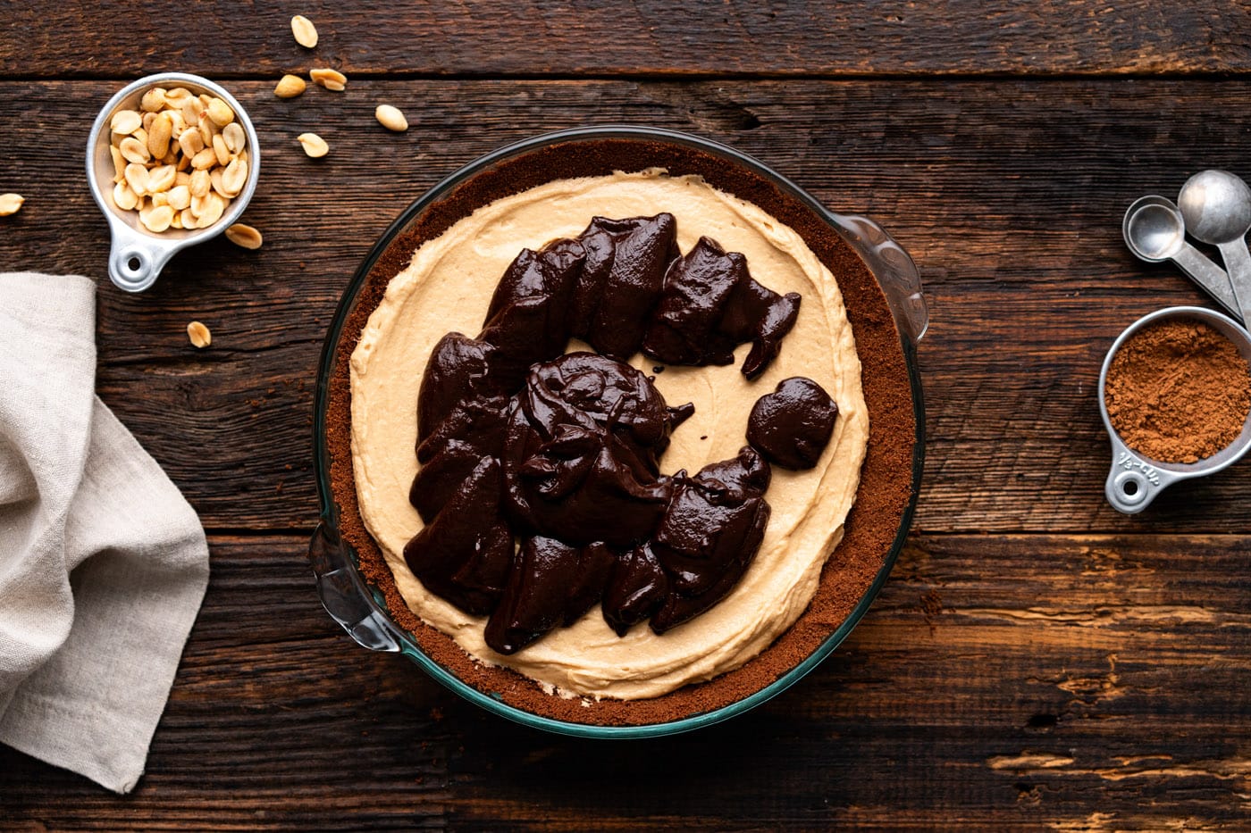 spreading chocolate ganache over peanut butter pie