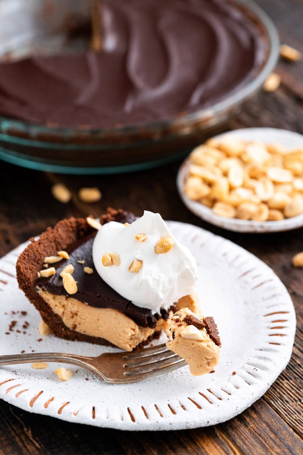 Slice of Chocolate Peanut Butter Pie on a plate with a piece on a fork