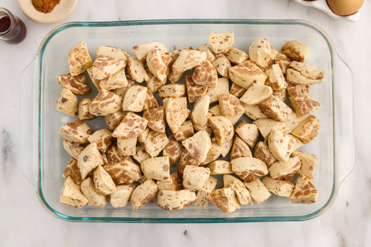 quartered cinnamon rolls in a baking dish