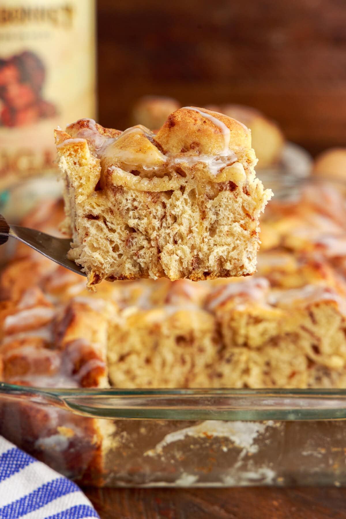 Serving of Cinnamon Roll Casserole being lifted out of the pan with a spatula