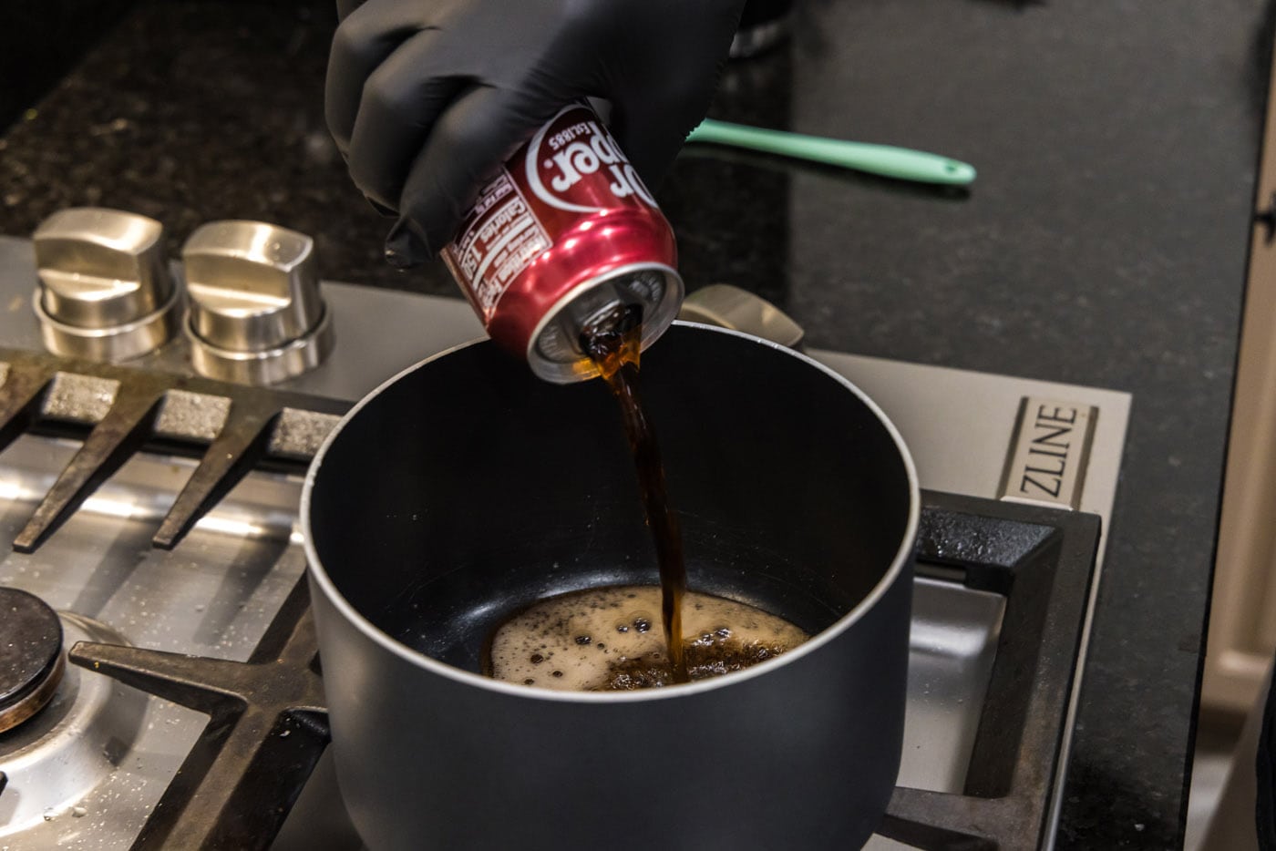 pouring dr. pepper into a saucepan