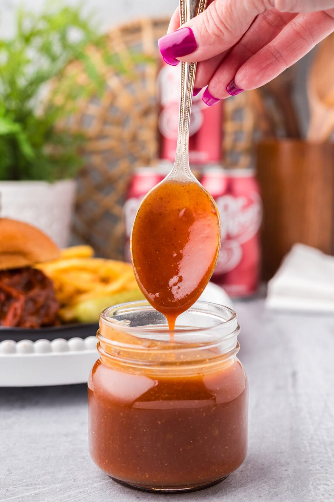 Dr Pepper Barbecue Sauce dripping off a spoon into a jar