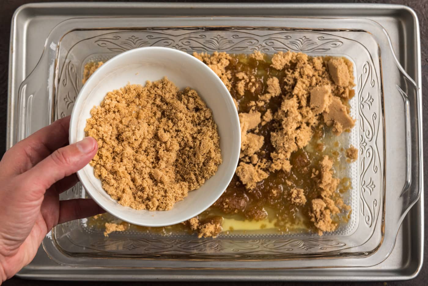 adding brown sugar to melted butter in baking dish
