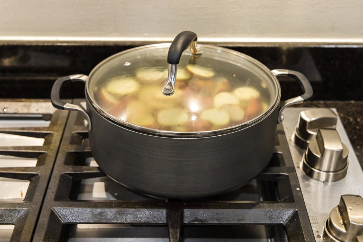 pot of red baby potatoes cooking with the lid