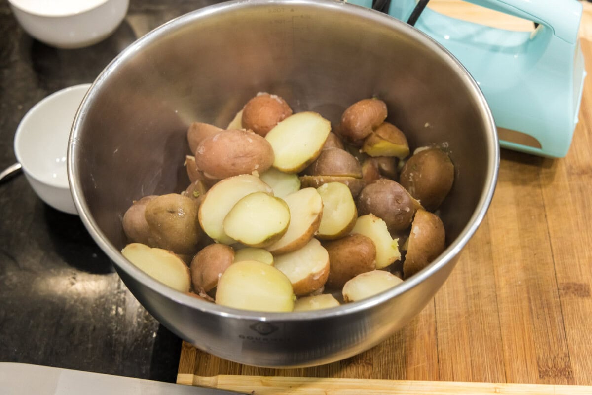 cooked sliced red potatoes in a mixing bowl