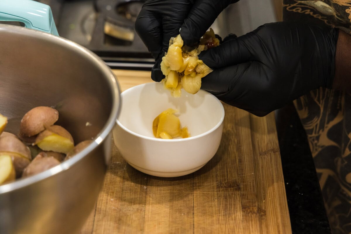 adding roasted garlic to a bowl