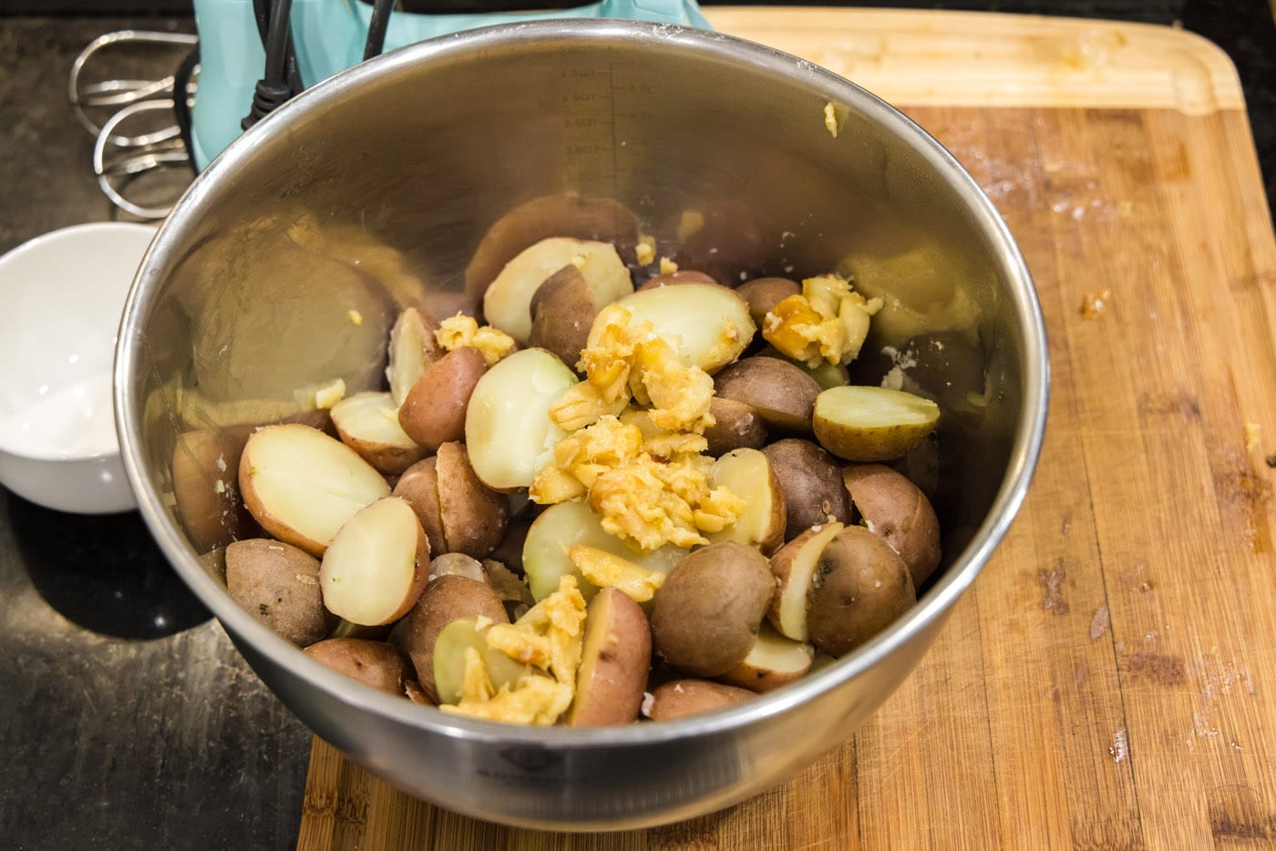 roasted garlic and baby red potatoes in a mixing bowl