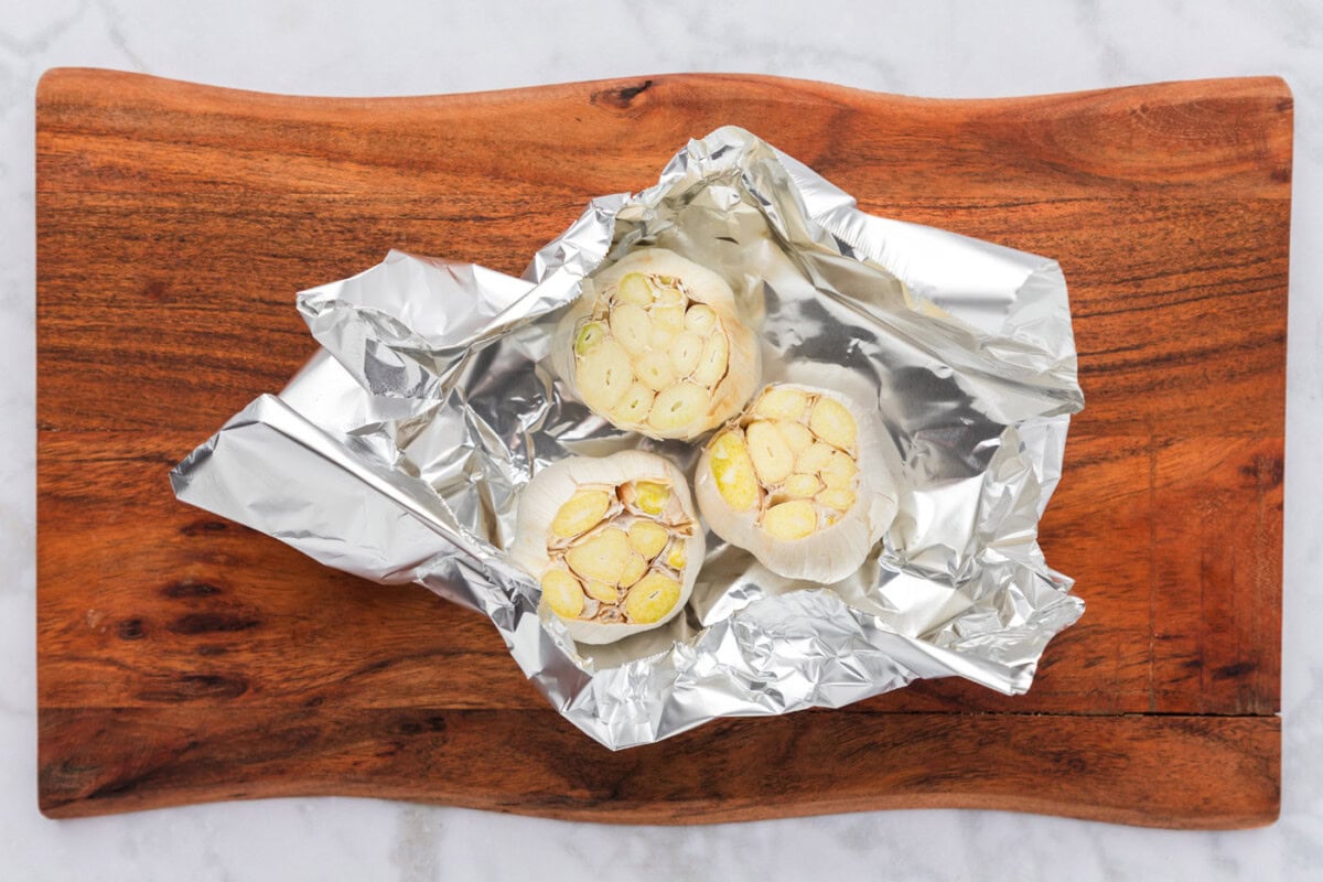 sliced whole bulbs of garlic in aluminum foil