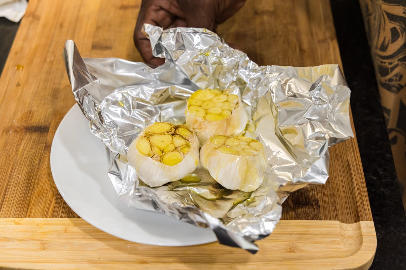 garlic bulbs in aluminum foil with olive oil