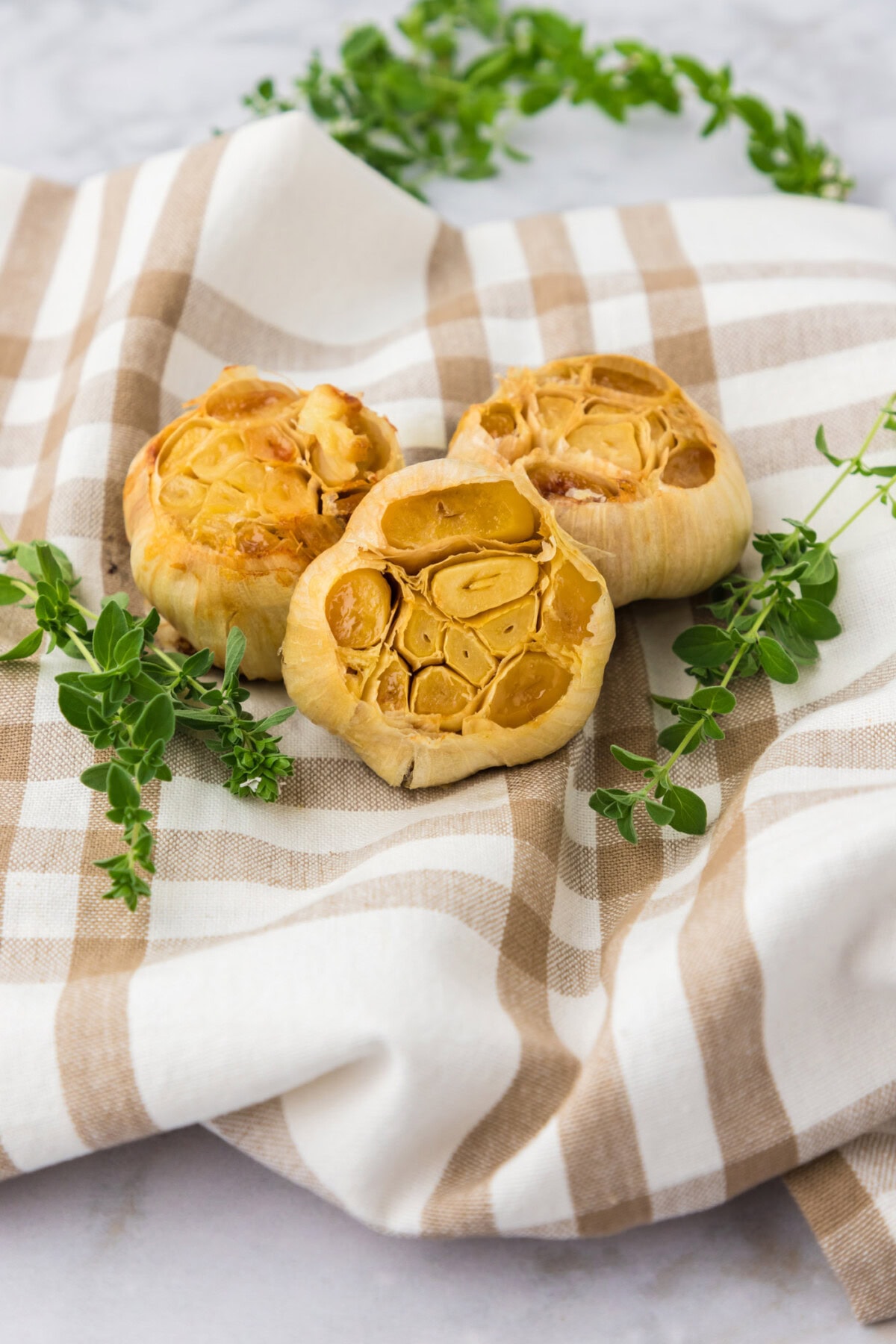 Three bulbs of roasted garlic on a towel