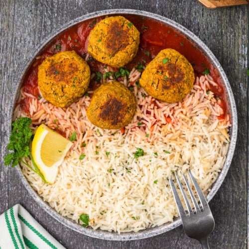 Four Lentil Meatballs on a plate with rice and a fork