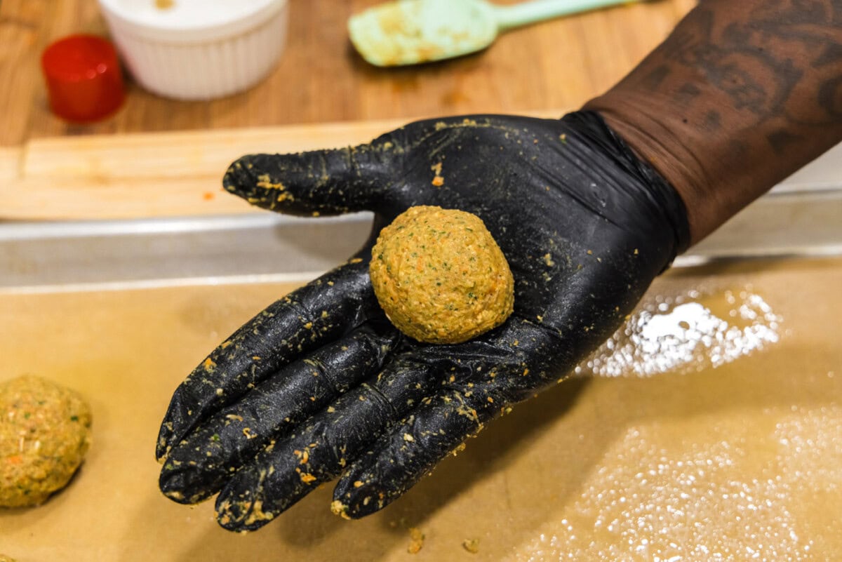 hand holding rolled lentil meatball
