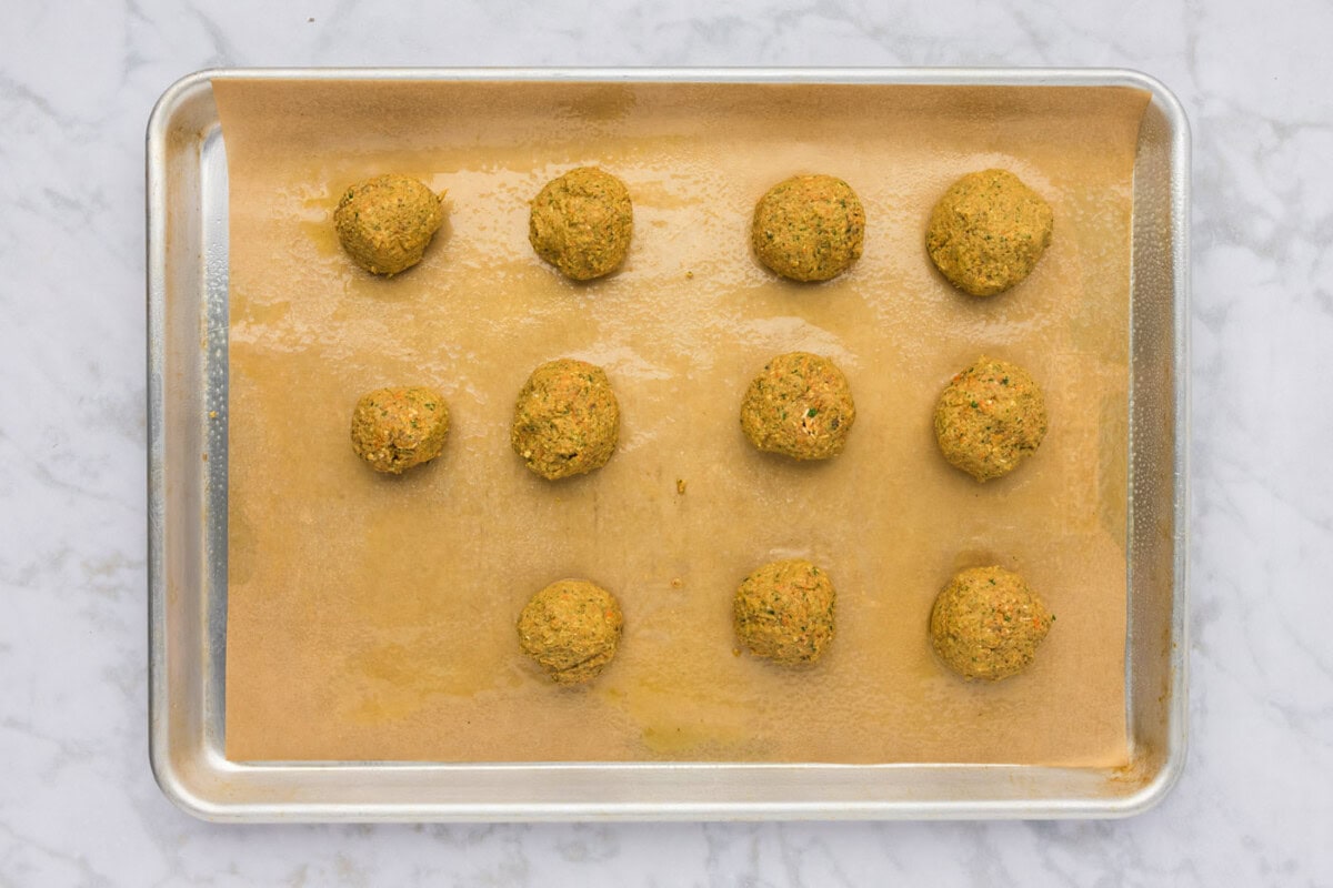 rolled lentil meatball dough on a baking sheet