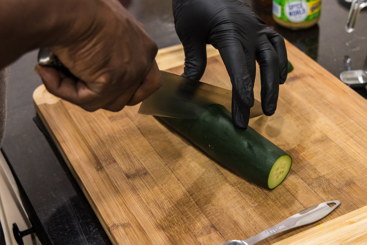 hand slicing cucumber with a knife