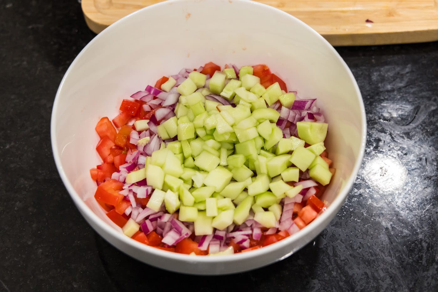 chopped cucumber added to roma tomatoes and red onion