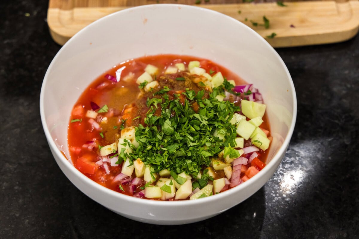 Clamato juice, ketchup, hot sauce, lime juice, lemon juice, cumin, and chopped cilantro in a bowl