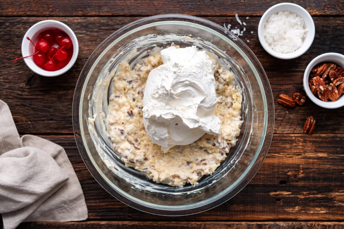 Adding cool whip to coconut, pineapple, and pecan pie filling