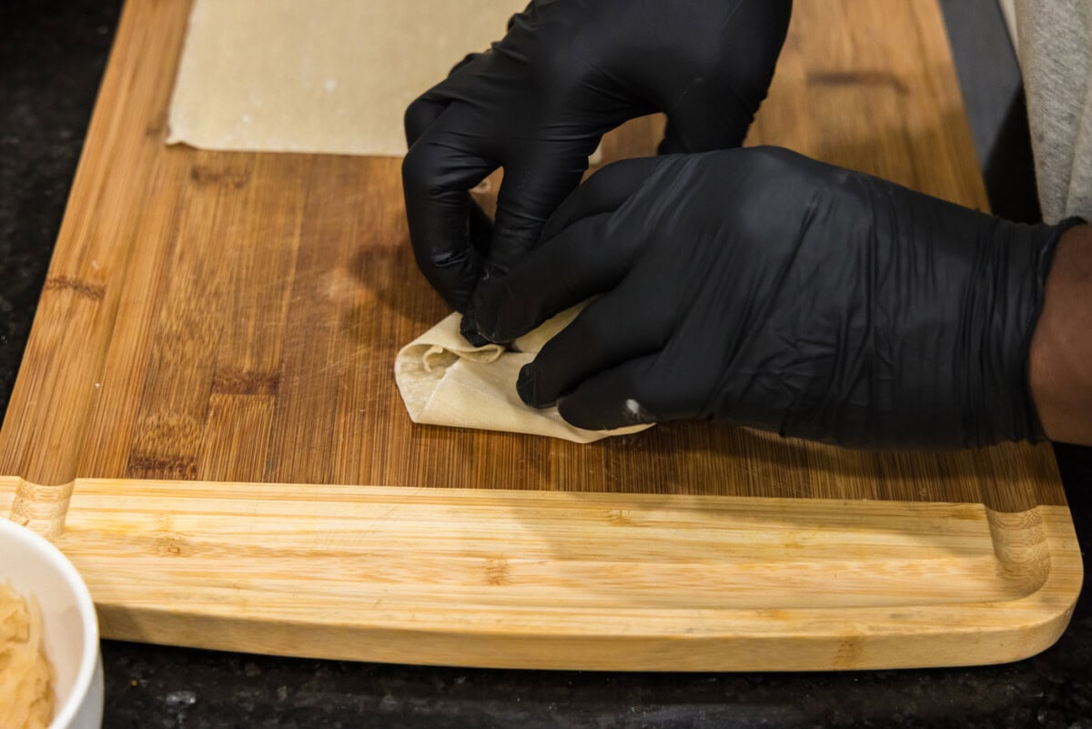demonstrating how to fold an egg roll wrapper