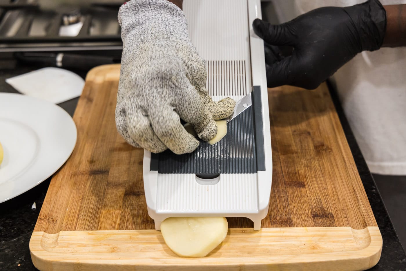slicing potatoes on a mandolin