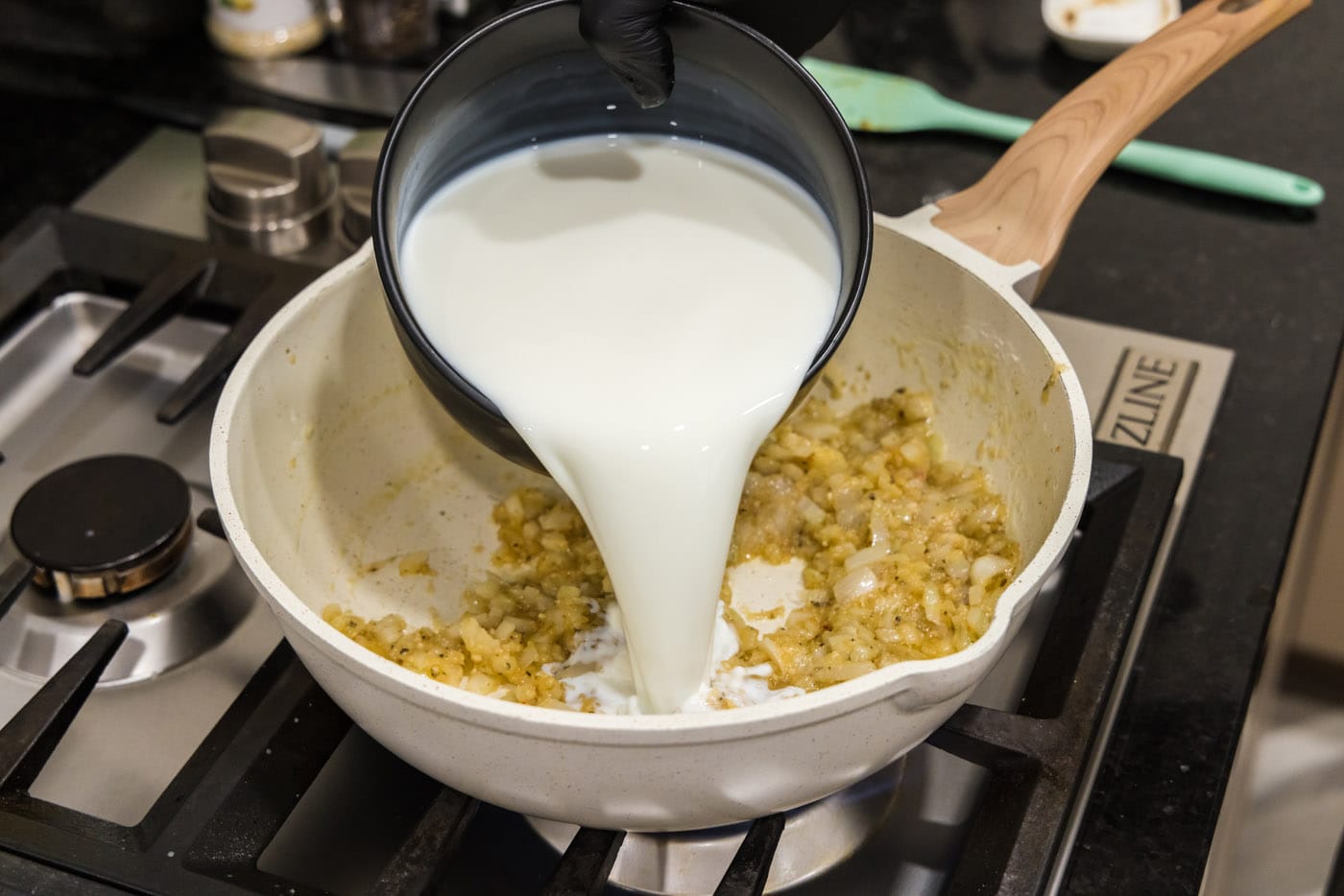 pouring milk into cream mixture