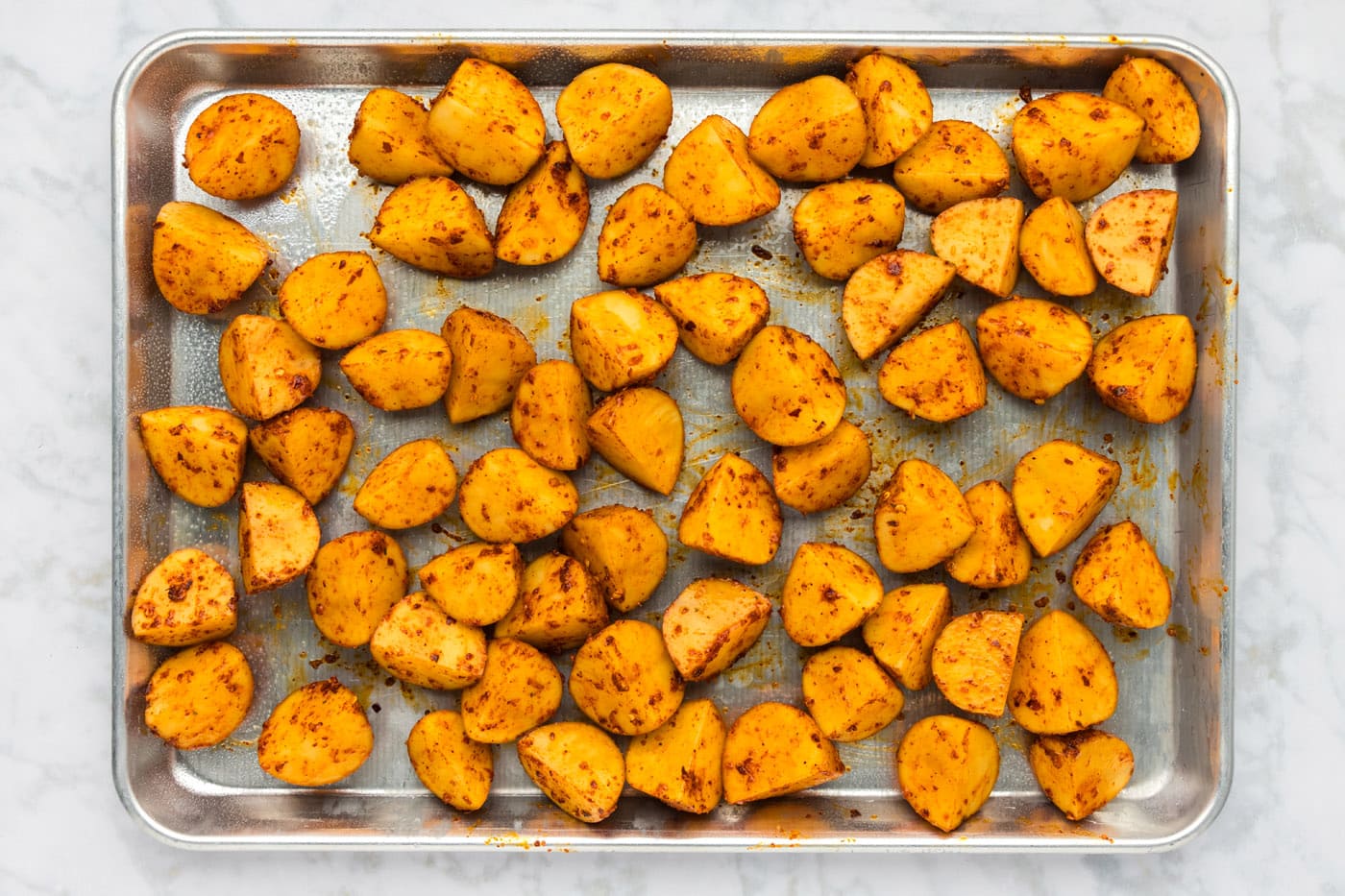 spicy potatoes on a large baking sheet