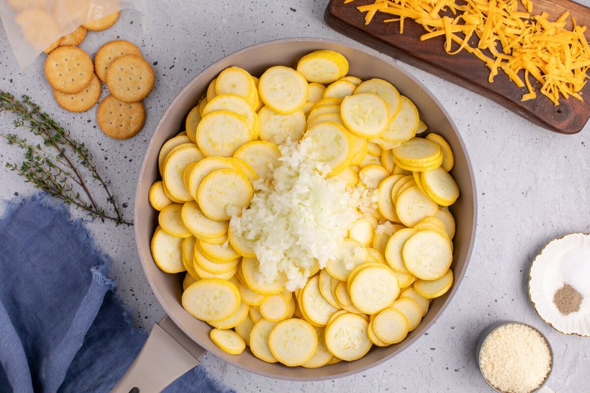 squash slices with chopped onion in a skillet