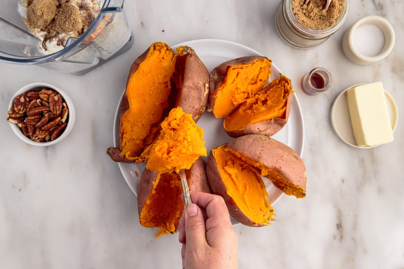 scooping sweet potatoes from the skin