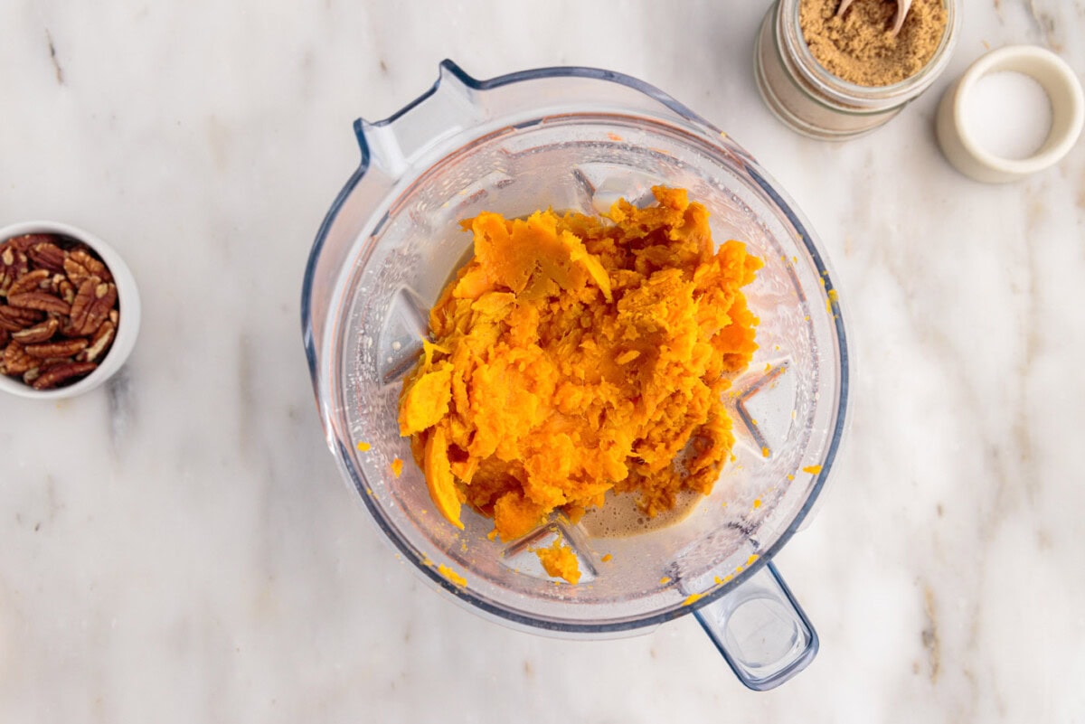 adding sweet potatoes to blender with souffle ingredients
