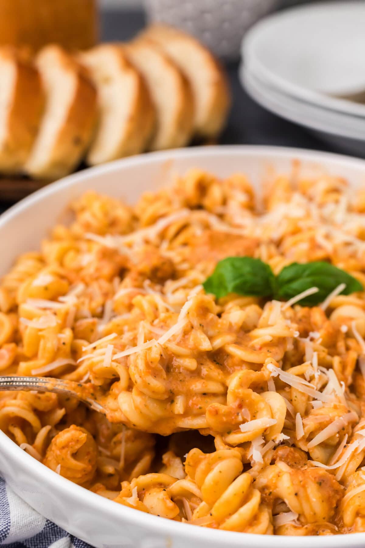 Close up photo of a spoon lifting out of a bowl of pasta covered in Vodka Sauce
