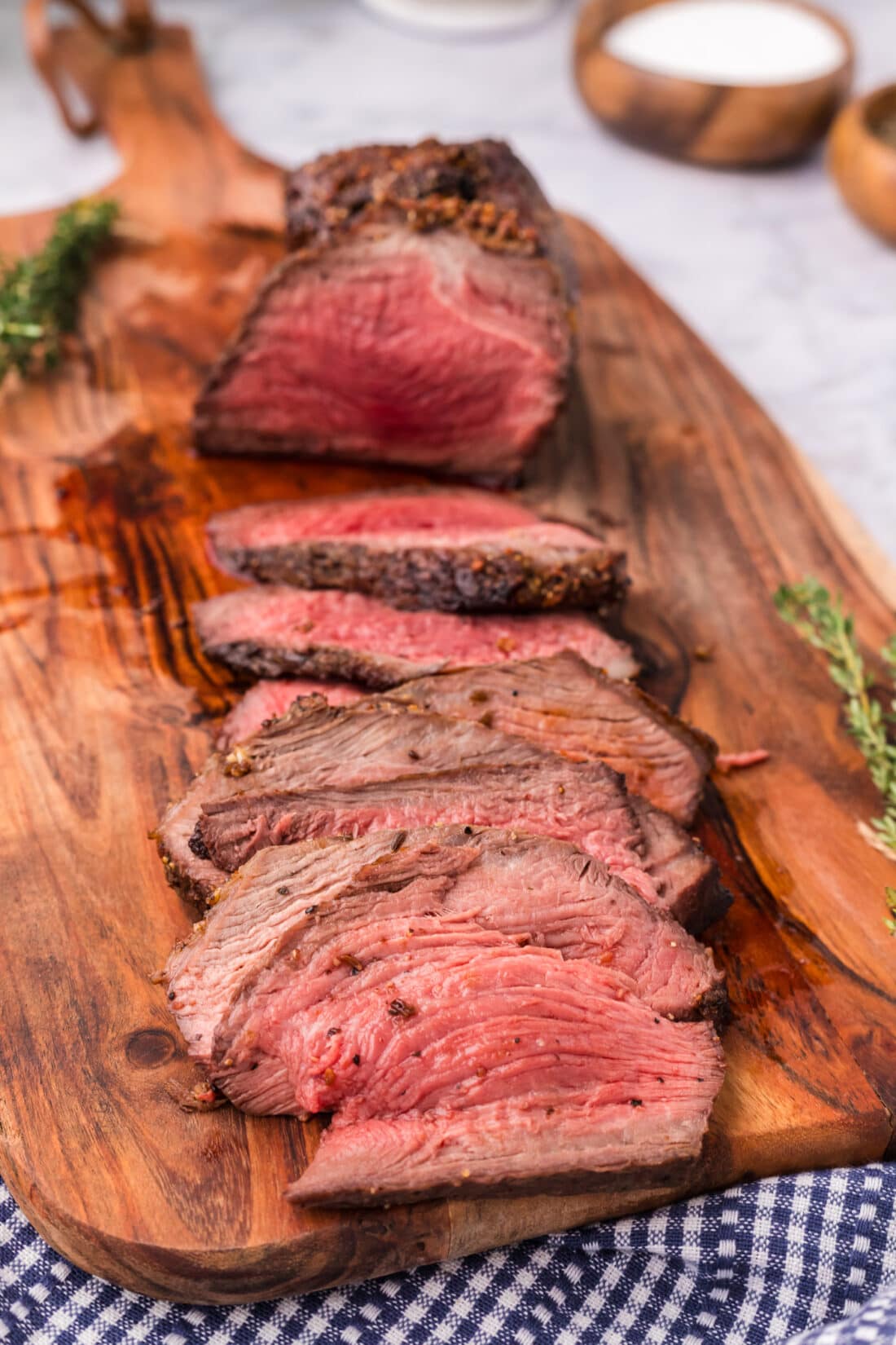 Slices of Air Fryer Roast Beef on a wooden cutting board