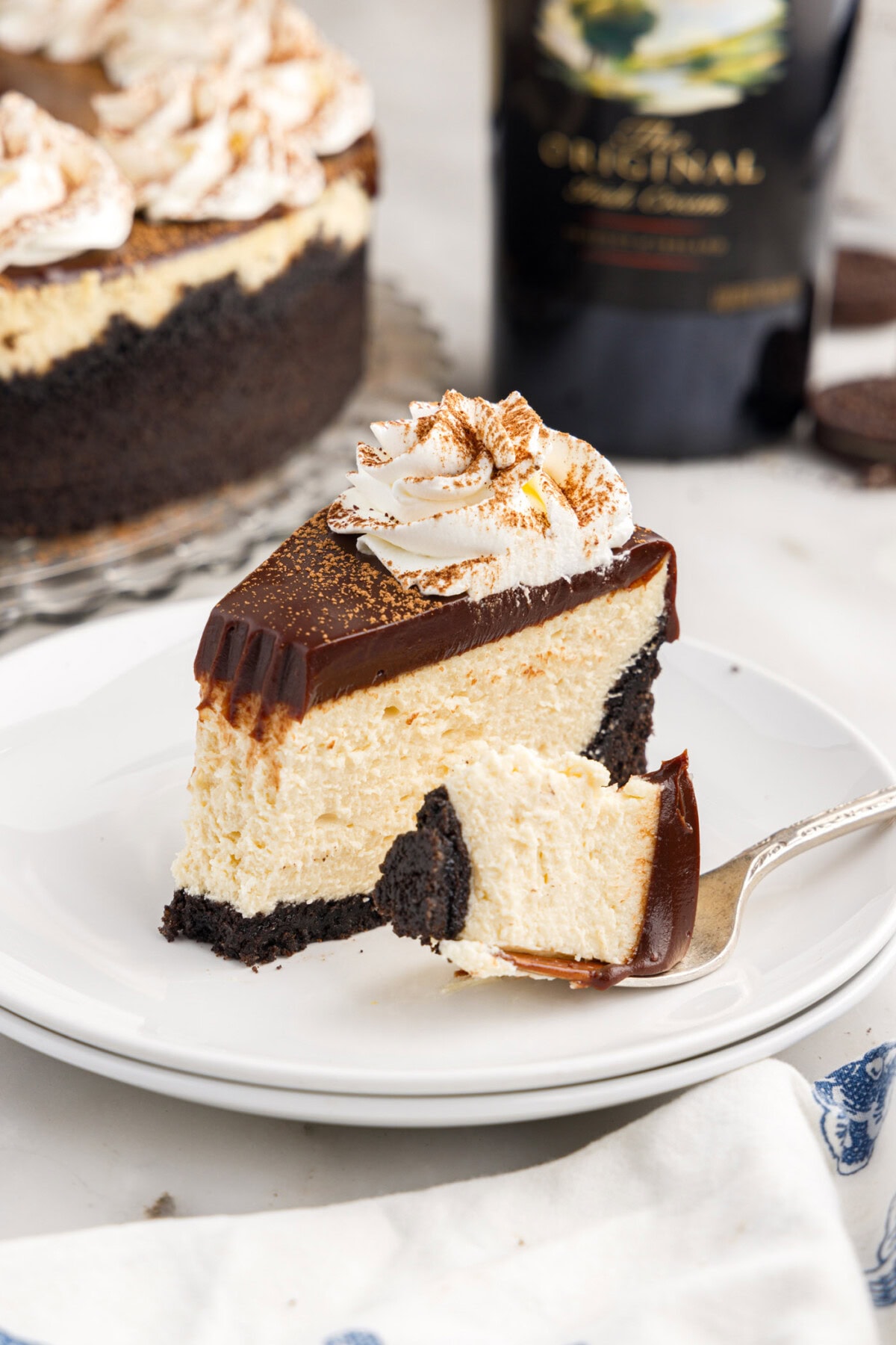 Slice of Baileys Cheesecake on a plate with a bite removed
