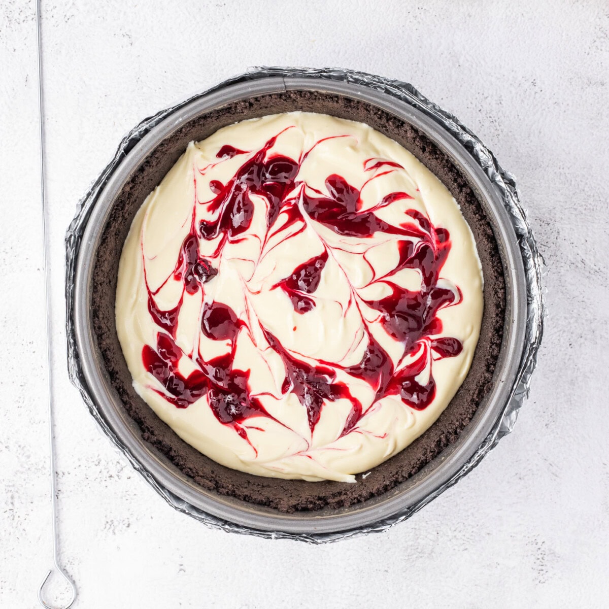 swirled blackberry reduction on top of cheesecake batter