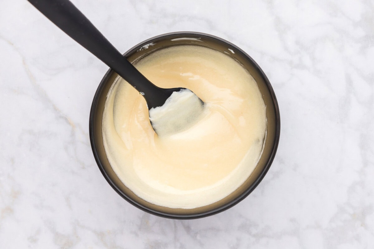 mayo dressing mixed in a bowl with a rubber spatula