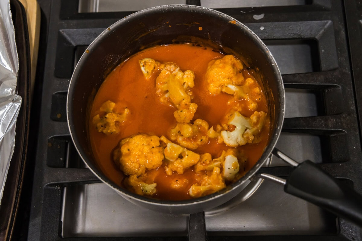 tossing cauliflower in buffalo sauce