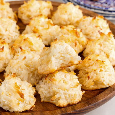 Coconut Macaroons on a wooden platter with a bite taken out of one