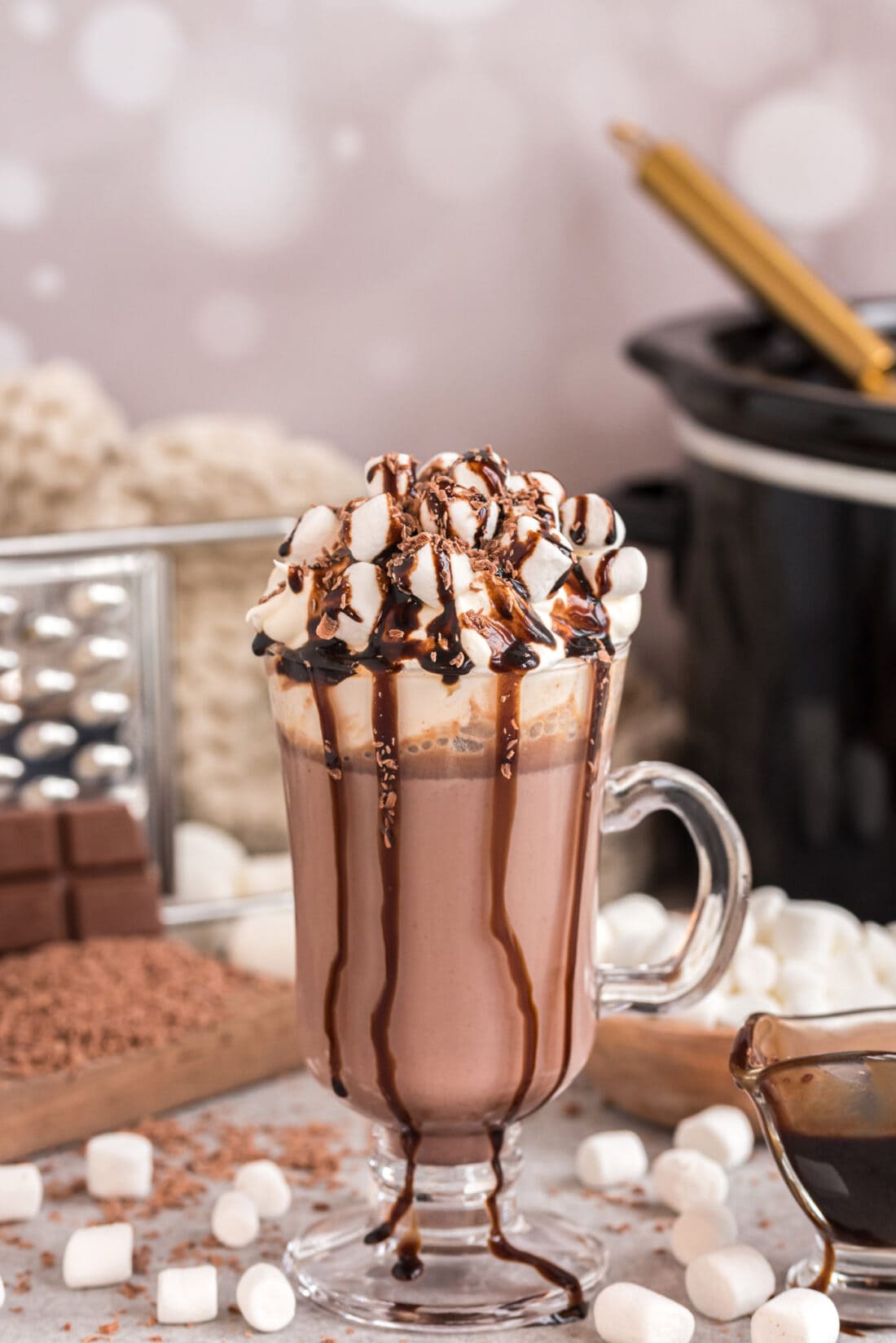 Crockpot Hot Chocolate in a mug topped with marshmallows and chocolate drizzle
