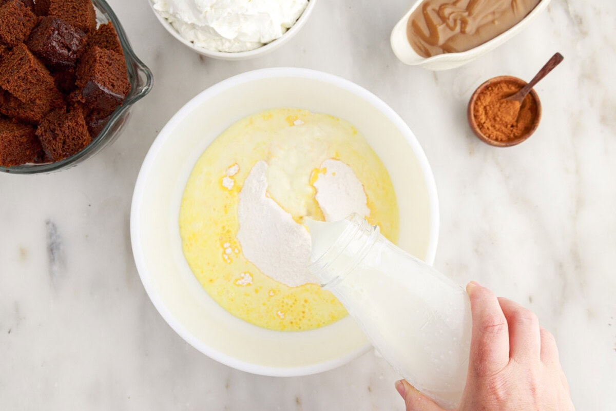 pouring instant pudding into bowl of milk