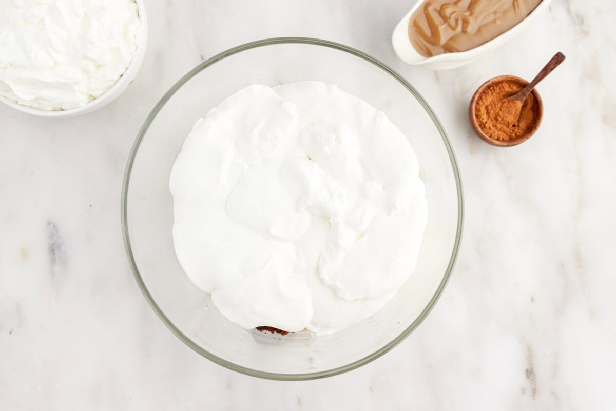 layer of whipped cream over pudding and gingerbread cake