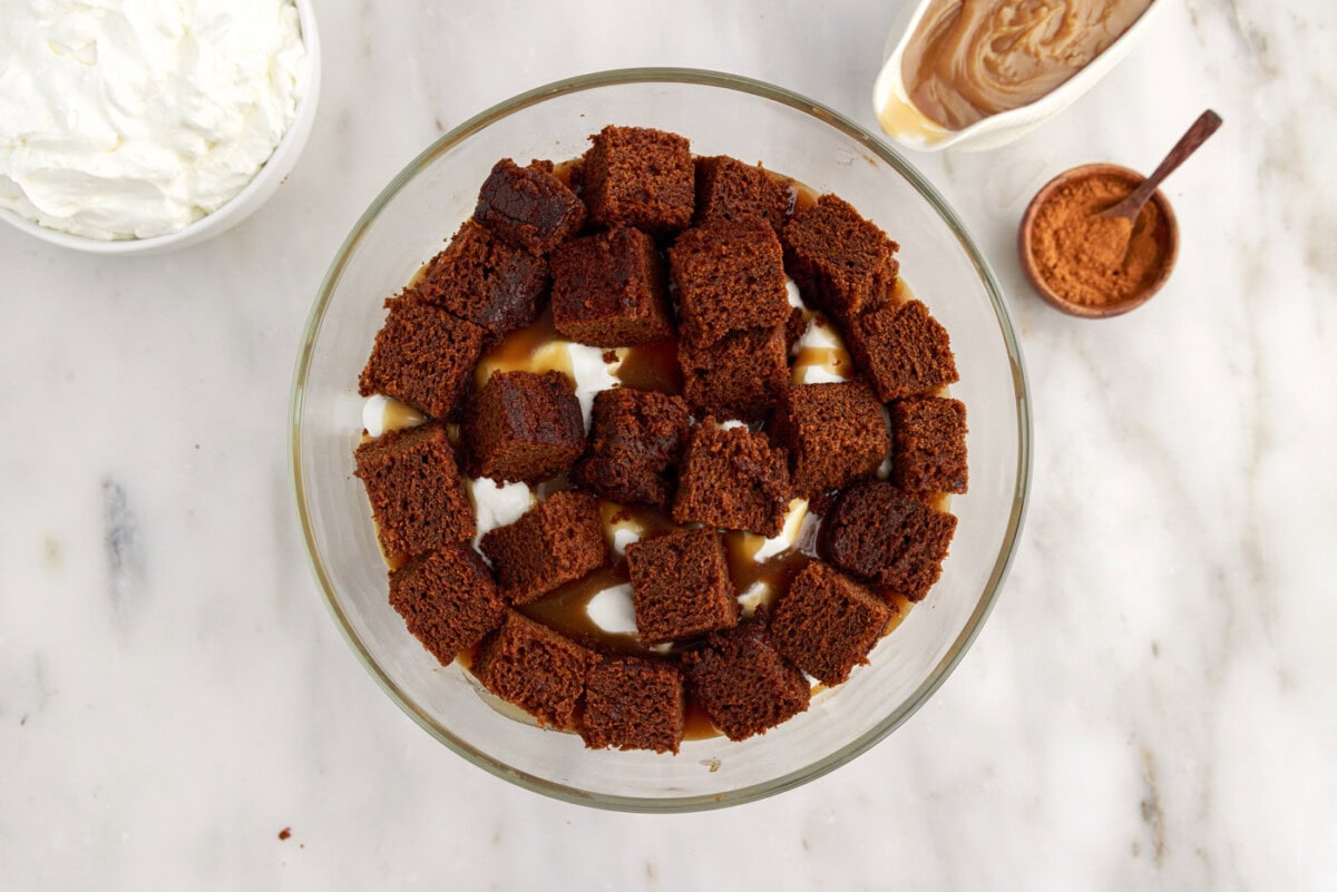 cubed gingerbread cake on top of caramel and whipped cream