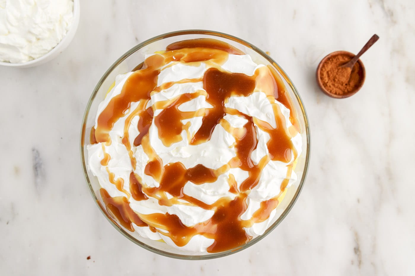 whipped cream and caramel sauce on top of gingerbread trifle