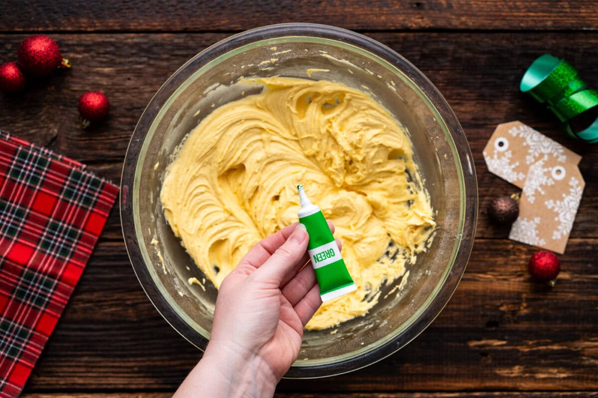adding green gel food coloring to cake mix cookie dough