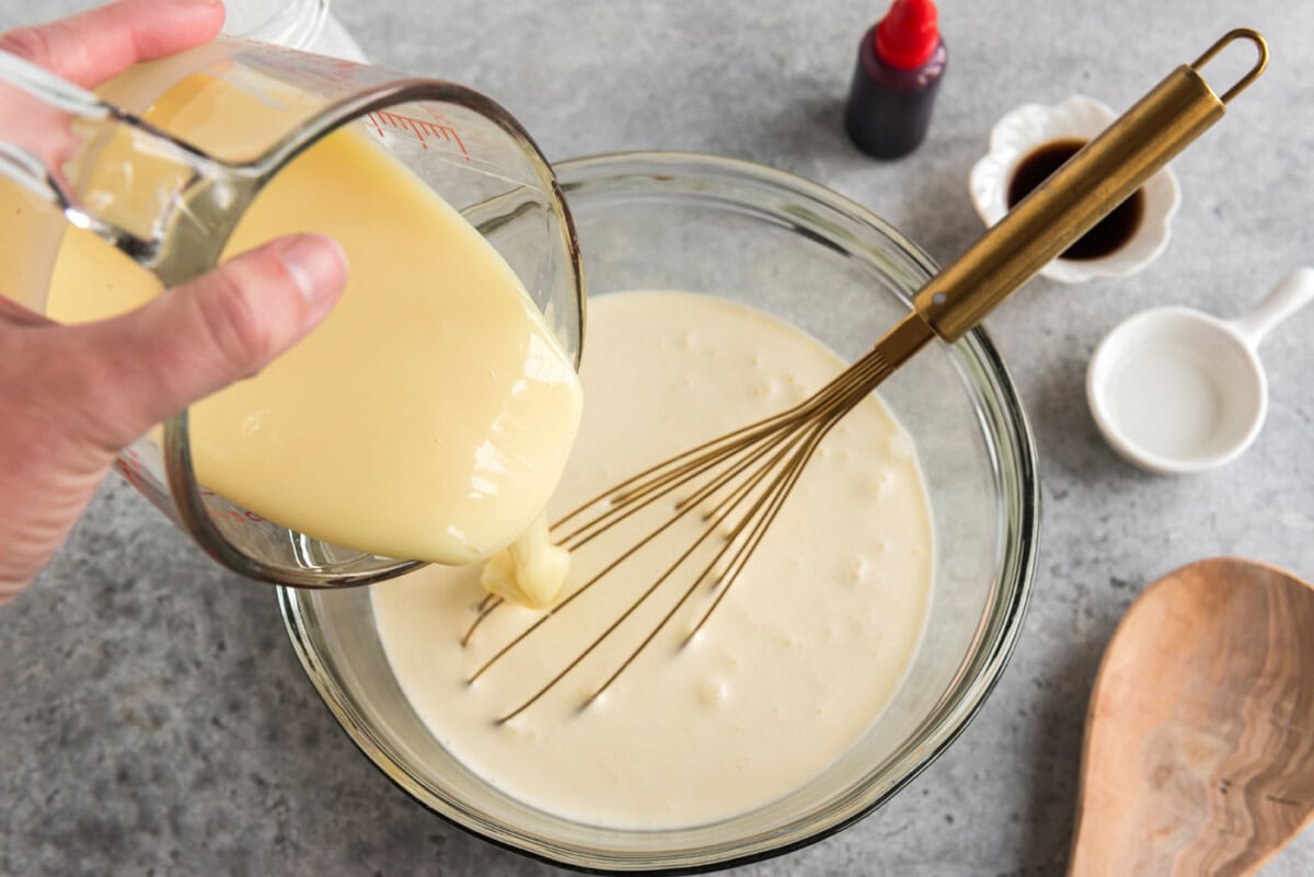 pouring sweetened condensed milk into ice cream mixture