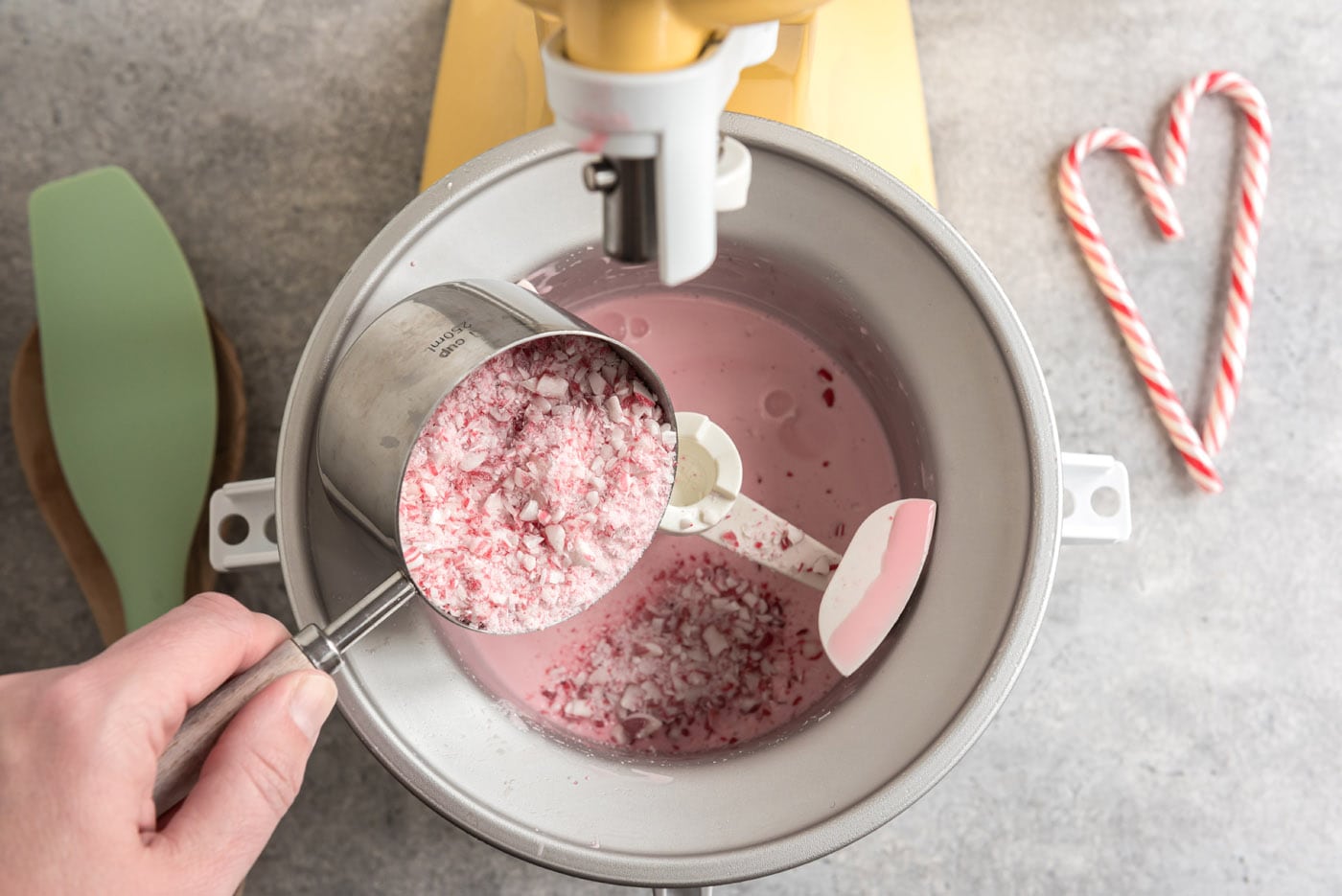 pouring crushed peppermint candies into ice cream maker