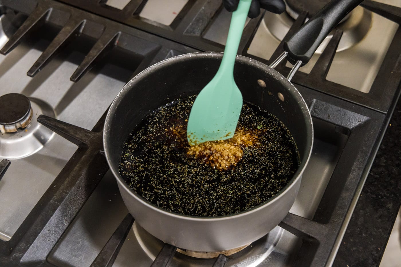 stirring honey garlic sauce in a saucepan