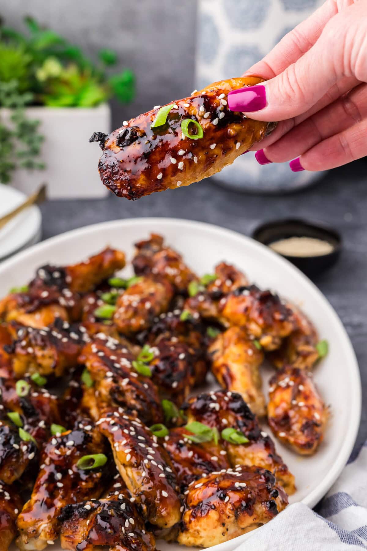 Hand holding up a Honey Garlic Chicken Wing